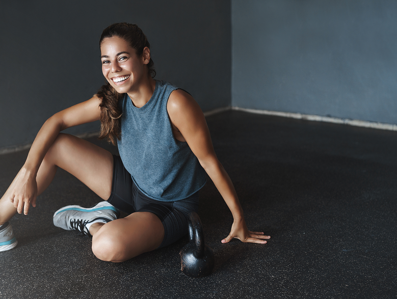 Sportive souriante posant avec une kettlebell